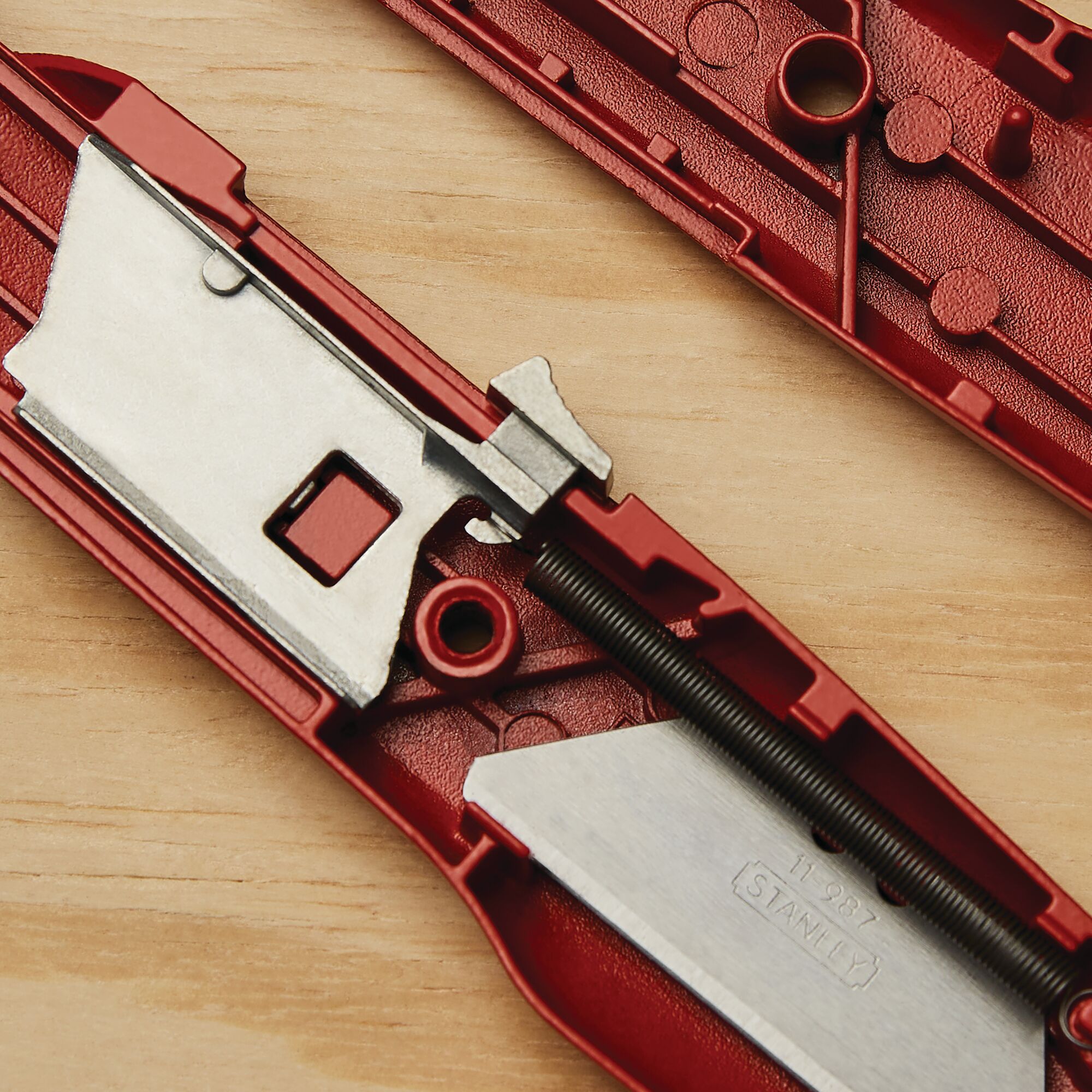 STANLEY 10-189C utility knife interior showing metal blade and red casing on wood surface.
