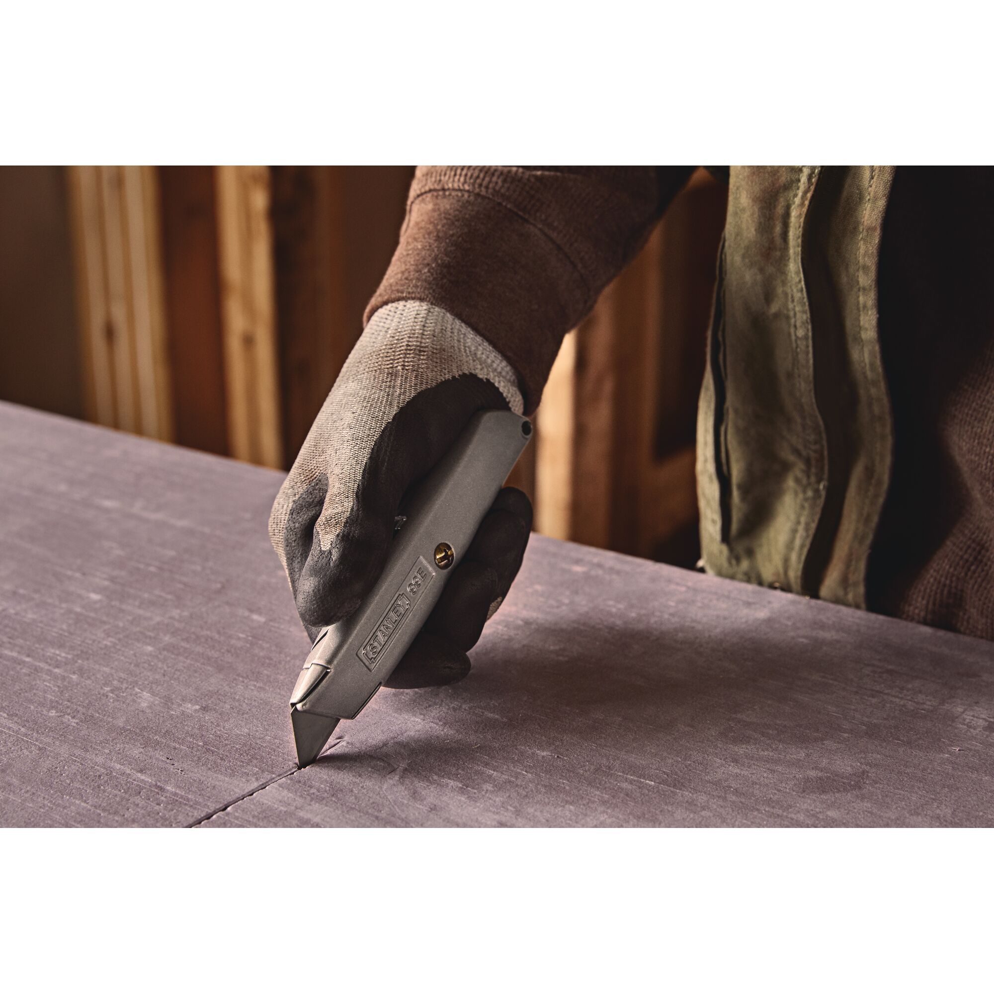Closeup of 6 Inch Classic 99 retractable utility knife cutting hard surface.
