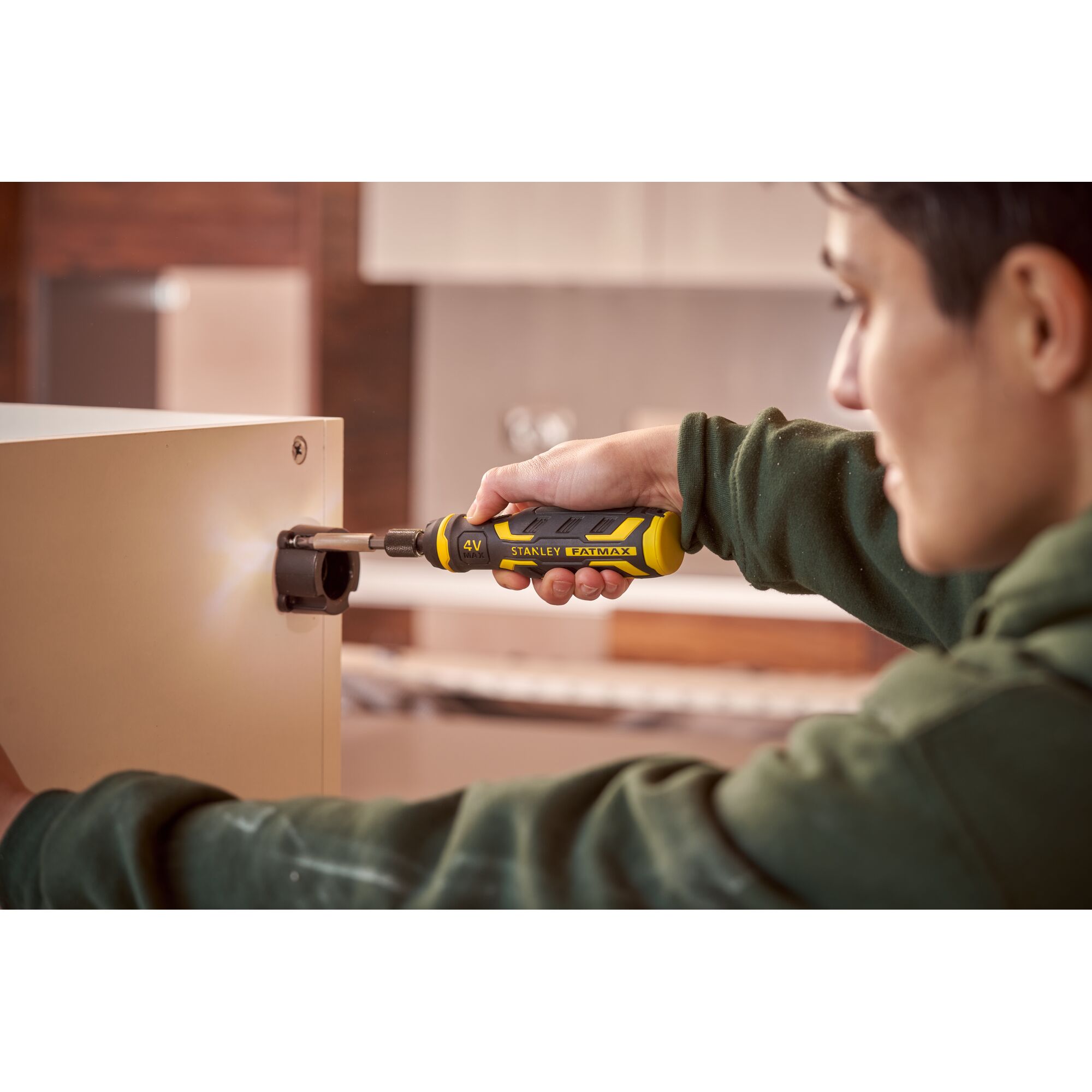 Stanley FMHT66719-0 FATMAX cordless screwdriver in use assembling furniture, yellow and black handle.